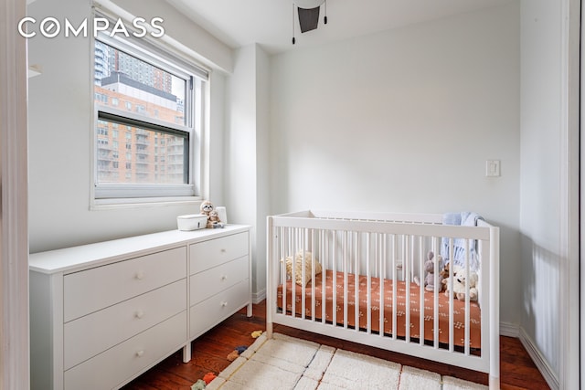 191 Willoughby St Unit 8J, New York City, NY 11201 - bedroom with wood finished floors, a nursery area, a ceiling fan, and baseboards