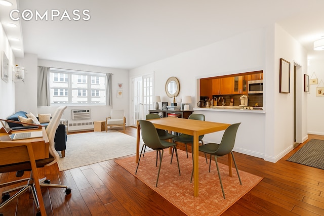 191 Willoughby St Unit 8J, New York City, NY 11201 - dining space with hardwood / wood-style floors, a wall unit AC, and baseboards