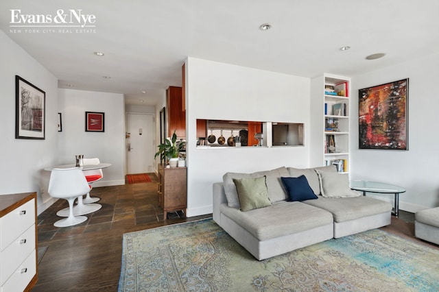 living room with recessed lighting, baseboards, and built in shelves