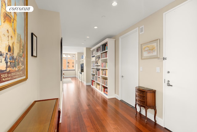 hallway with wood finished floors, recessed lighting, and baseboards