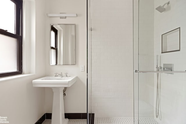 bathroom with a shower stall, plenty of natural light, and baseboards