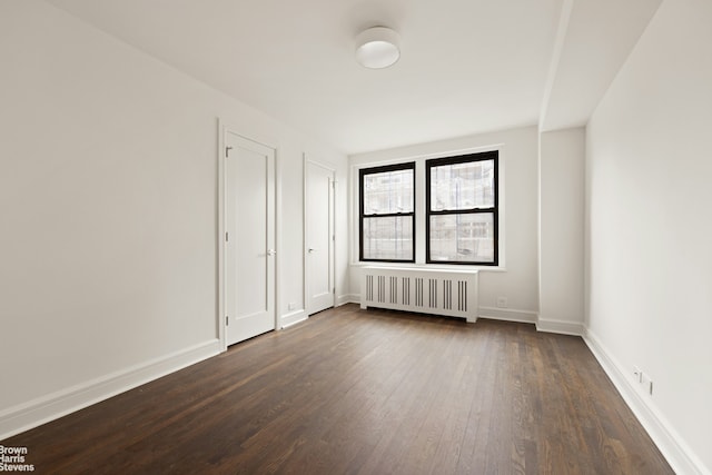 205 E 78th St Unit 17H, New York City, NY 10075 - unfurnished bedroom featuring radiator and dark wood-style floors