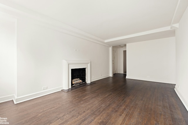 unfurnished living room featuring dark wood-type flooring, a fireplace with raised hearth, and baseboards