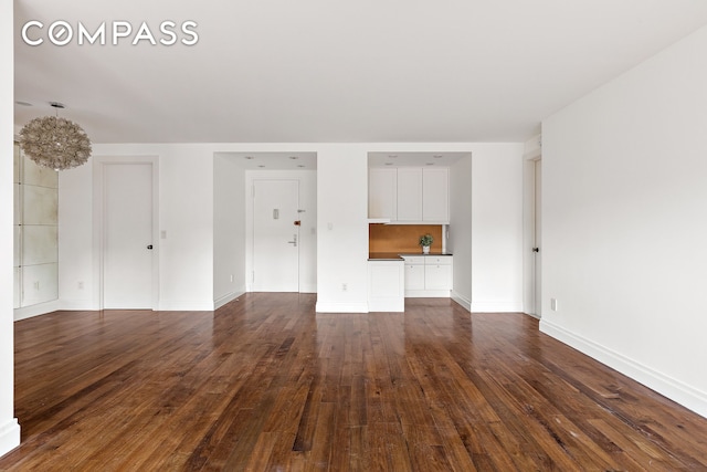 70 E 10th St Unit 14P, New York City, NY 10003 - unfurnished living room featuring dark wood-style floors and baseboards