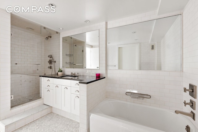 70 E 10th St Unit 14P, New York City, NY 10003 - bathroom featuring tile patterned flooring, a shower stall, tile walls, vanity, and a garden tub