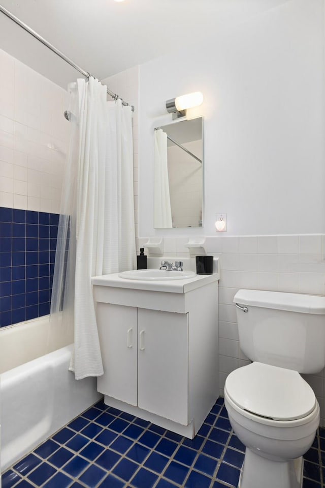 full bath with toilet, tile patterned flooring, shower / tub combo with curtain, vanity, and tile walls