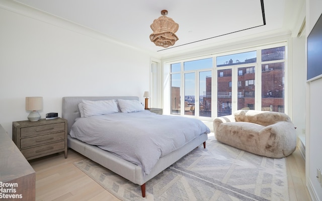 bedroom featuring light wood-style flooring and ornamental molding