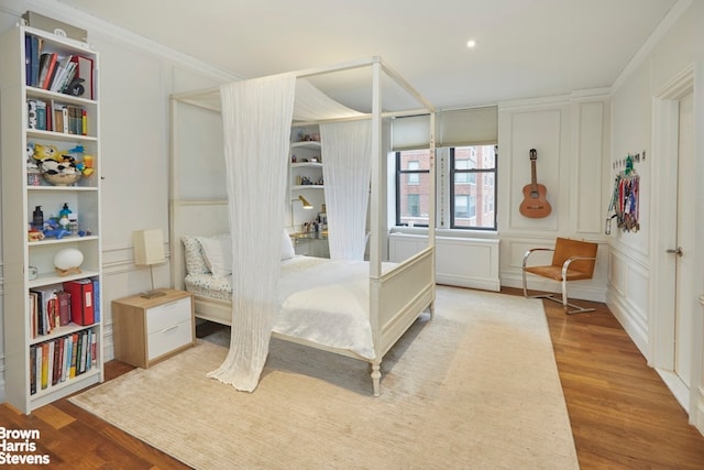 219 W 81st St Unit 6A, New York City, NY 10024 - bedroom with wood finished floors, a decorative wall, and ornamental molding