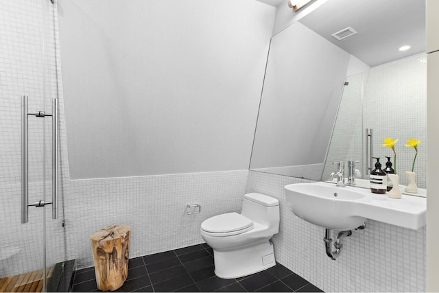 105 Norfolk St Unit Tower15, New York City, NY 10002 - bathroom with tile walls, a shower stall, wainscoting, toilet, and tile patterned floors