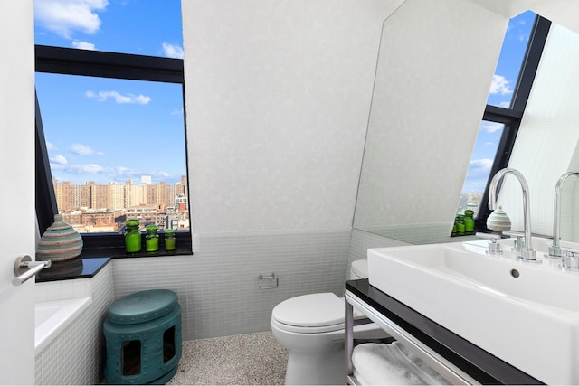 105 Norfolk St Unit Tower15, New York City, NY 10002 - bathroom featuring tile walls, toilet, a wainscoted wall, a city view, and speckled floor