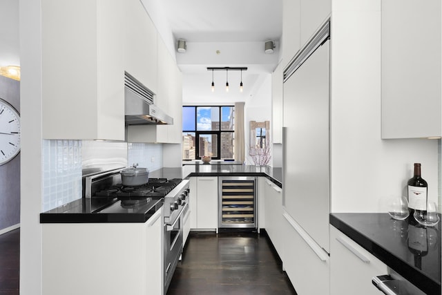 105 Norfolk St Unit Tower15, New York City, NY 10002 - kitchen featuring wine cooler, under cabinet range hood, high end appliances, dark countertops, and white cabinetry