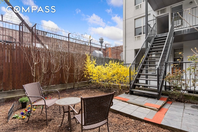 view of patio / terrace with stairway and fence
