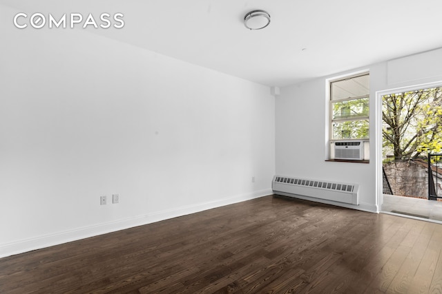 unfurnished room with radiator, dark wood-style floors, baseboards, and cooling unit