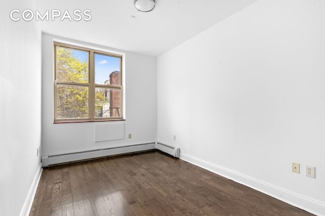 unfurnished room with a baseboard heating unit, dark wood-style flooring, and baseboards