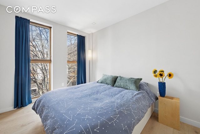 bedroom with baseboards and wood finished floors