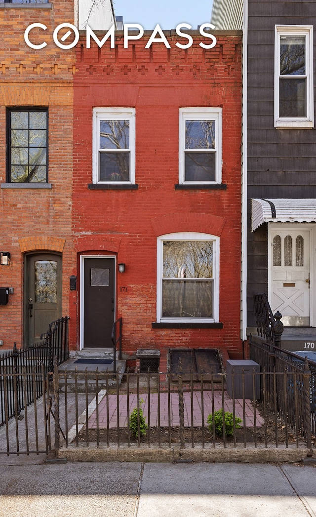 171 Monitor St, New York City, NY 11222 - view of property featuring a fenced front yard and brick siding