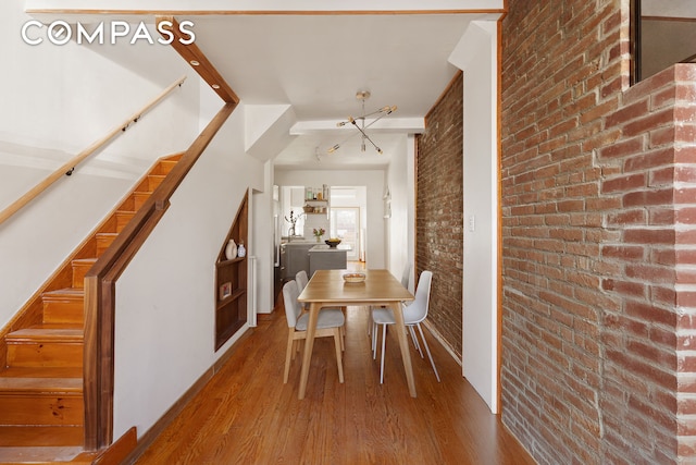 171 Monitor St, New York City, NY 11222 - dining space with brick wall, wood finished floors, and stairway