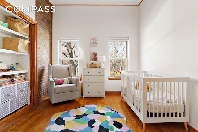 171 Monitor St, New York City, NY 11222 - bedroom featuring wood finished floors, brick wall, and baseboards