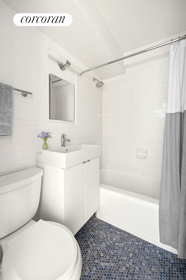 full bath with tile walls, toilet, shower / bath combo, vanity, and tile patterned floors