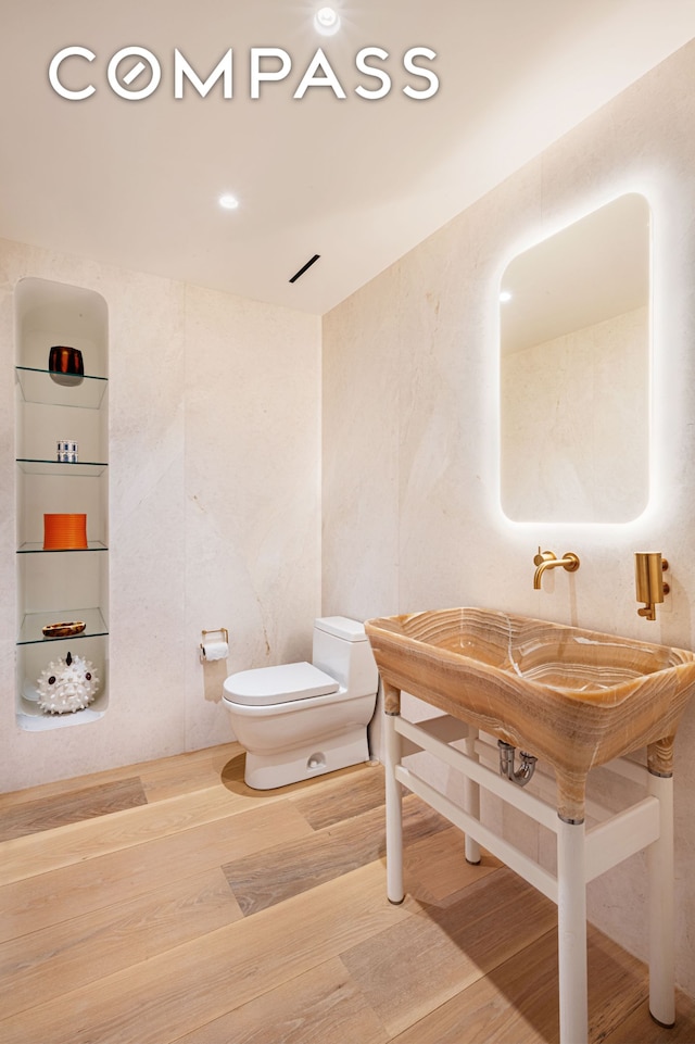 bathroom featuring wood finished floors and toilet