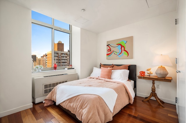 121 E 23rd St Phd, Phd, New York City, NY 10010 - bedroom with hardwood / wood-style flooring, attic access, radiator, and a city view