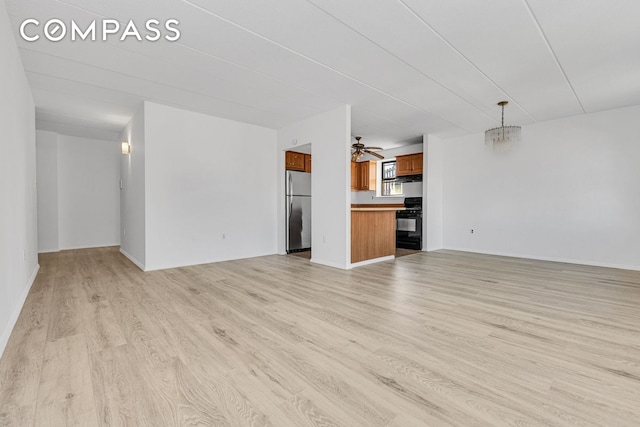 unfurnished living room with ceiling fan, baseboards, and light wood-style flooring