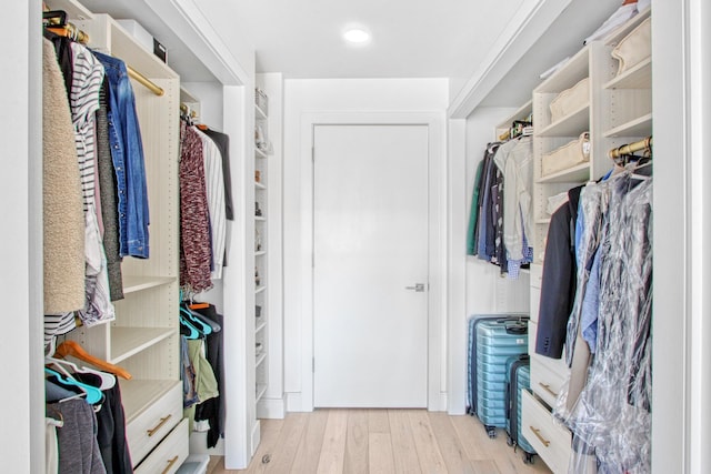 walk in closet with wood finished floors
