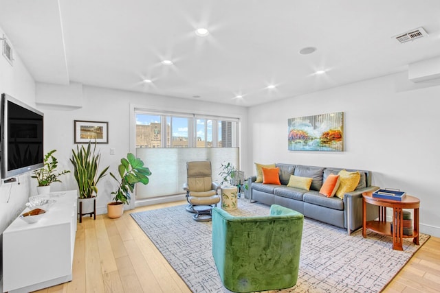 living area featuring recessed lighting, baseboards, visible vents, and light wood finished floors