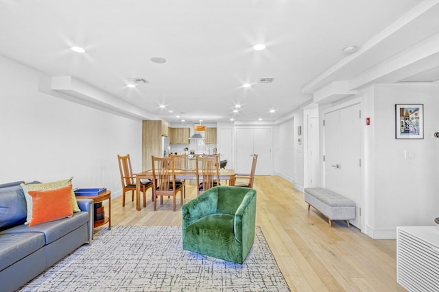 living area featuring recessed lighting, baseboards, visible vents, and light wood-style flooring