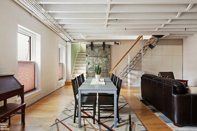 1 Worth St Unit 6R, New York City, NY 10013 - dining room with stairway, light wood finished floors, and beam ceiling