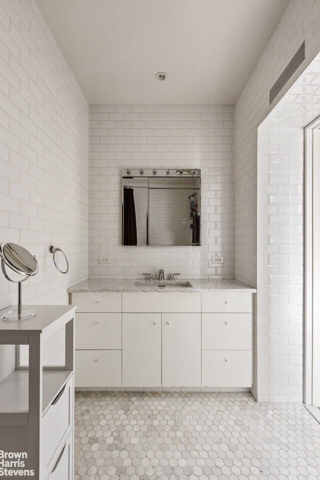 bathroom with tile patterned floors, vanity, and tile walls