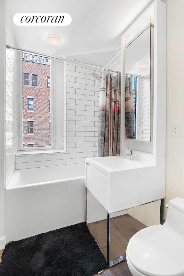 15 William St Unit 23A, New York City, NY 10005 - full bathroom featuring toilet, vanity, shower / bath combo, and wood finished floors