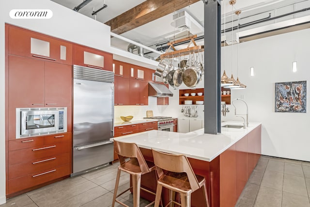 kitchen featuring built in appliances, a sink, under cabinet range hood, and light tile patterned floors