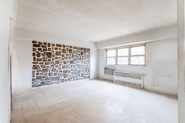 609 Columbus Ave Unit 4A, New York City, NY 10024 - unfurnished room featuring tile patterned floors, radiator heating unit, a wall unit AC, and a textured ceiling