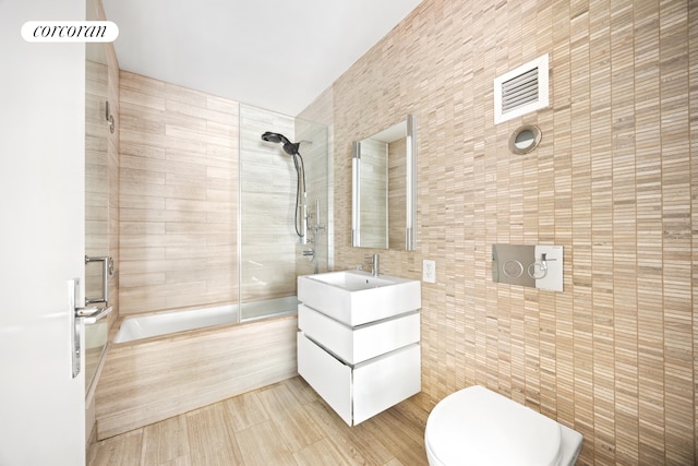 421 Hudson St Unit 214, New York City, NY 10014 - bathroom with tile walls, shower / washtub combination, toilet, and vanity