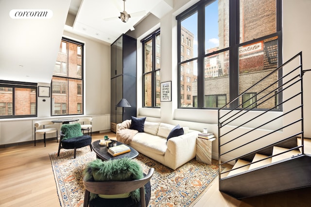 421 Hudson St Unit 214, New York City, NY 10014 - living room featuring wood finished floors, stairway, baseboards, and a ceiling fan