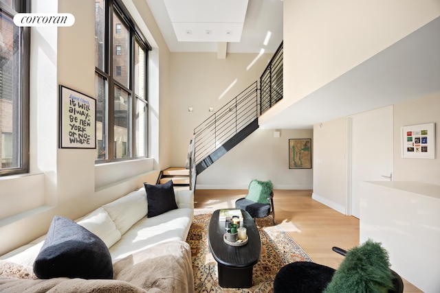 421 Hudson St Unit 214, New York City, NY 10014 - living room featuring stairway, wood finished floors, a high ceiling, and baseboards