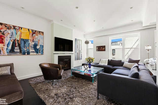 living room with baseboards, a glass covered fireplace, wood finished floors, crown molding, and recessed lighting