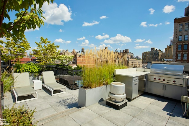 view of patio / terrace featuring a grill, an outdoor kitchen, and a city view