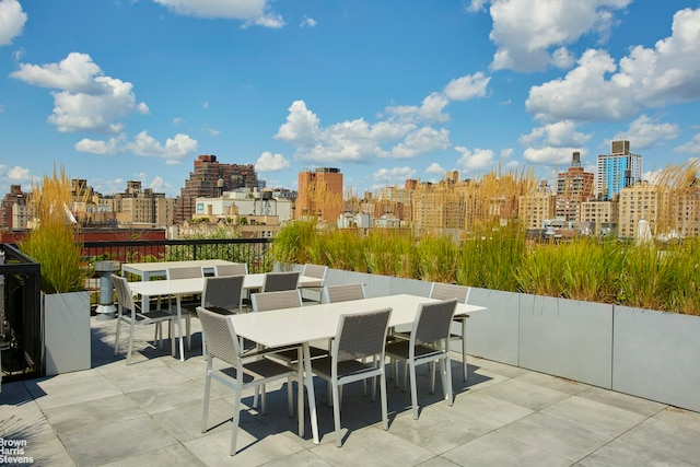 view of patio with outdoor dining area and a skyline view