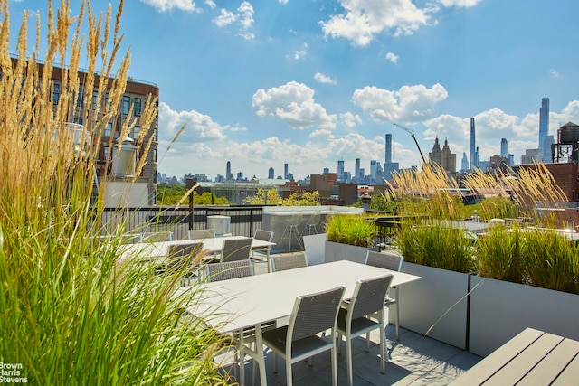 wooden terrace featuring a view of skyline and outdoor dining area