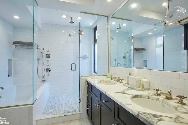 bathroom with a stall shower, double vanity, recessed lighting, and tiled bath
