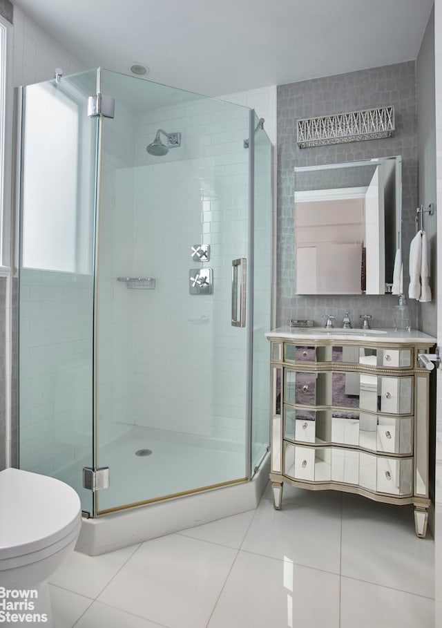 full bath with tile patterned floors, a shower stall, toilet, and vanity