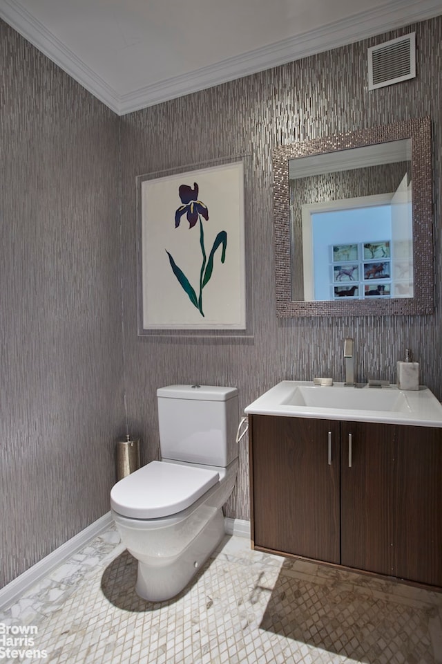 bathroom featuring toilet, crown molding, vanity, and baseboards