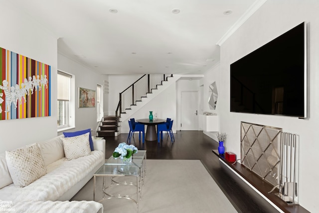 living room with stairway, wood finished floors, and ornamental molding