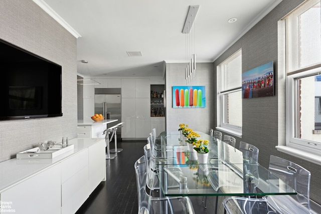 dining space with crown molding and dark wood-style floors