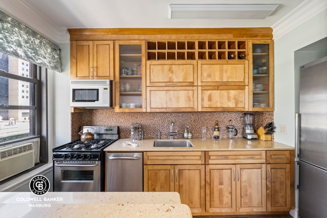 kitchen featuring appliances with stainless steel finishes, a sink, tasteful backsplash, glass insert cabinets, and crown molding