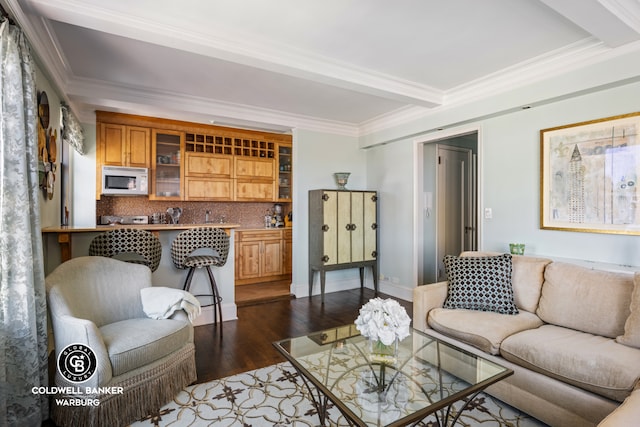 living room with wood finished floors, ornamental molding, and beam ceiling