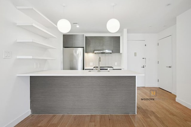 10-55 47th Ave Unit 5-E, New York City, NY 11101 - kitchen with stainless steel refrigerator, light countertops, under cabinet range hood, modern cabinets, and open shelves