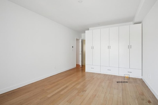 10-55 47th Ave Unit 5-E, New York City, NY 11101 - unfurnished bedroom with light wood-style floors and baseboards